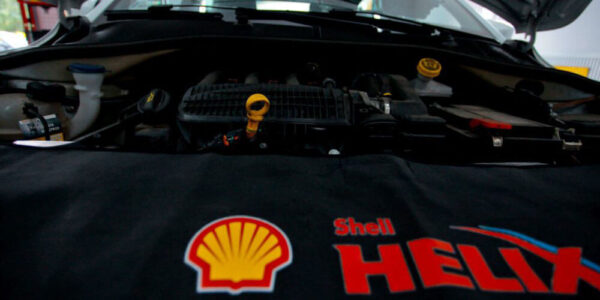 Wnętrze silnika samochodowego i logo Shell Helix.